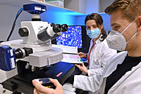 PD Dr. Ivonne Löffler und Eric Jankowski (r.) untersuchen Gewebeproben am Mikroskop.